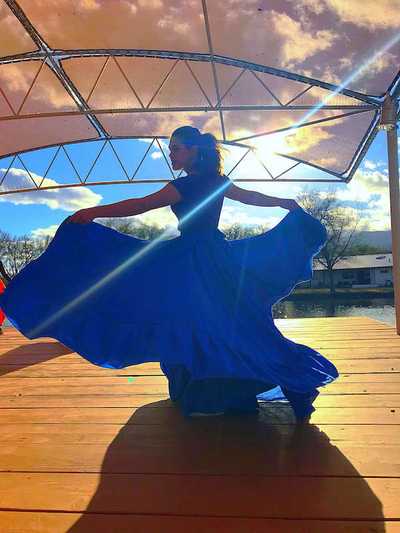 young woman spinning in a blue dress.