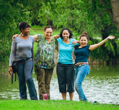 Women smiling in front of pond.