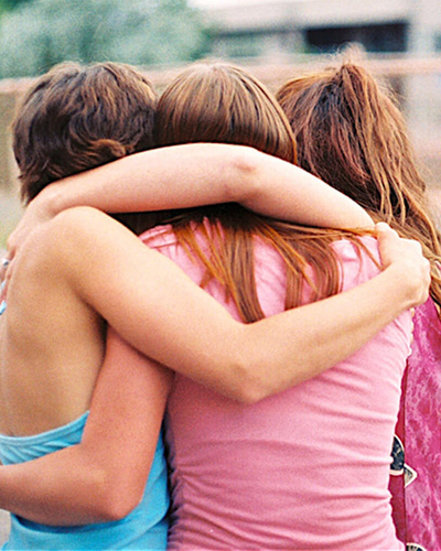 Teenage girls hugging.