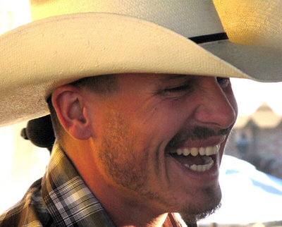 Man with cowboy hat smiling.