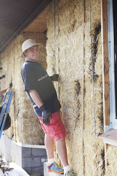 A young man working with straw.